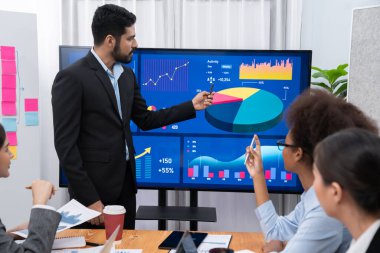 Pazarlama stratejisi için modern toplantıda veri analizi paneli ekranında sunan bir işadamı. Bir grup iş adamıyla konferans odasında iş sunumu. Uyum