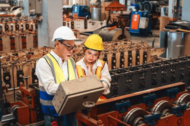 Fabrika mühendisi, endüstriyel çelik oluşum makinesinin asistan teftişi ile birlikte metal fabrikası mühendisliği denetleyicisi olarak liderlik örneğini sunuyor..