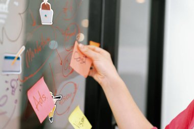 Profesyonel iş kadınının elini kapat ve iş planını sunarken renkli yapışkan notları beyaz tahtaya yapıştır. Yaratıcı iş toplantısı ve beyin fırtınası konsepti. Tertemiz..