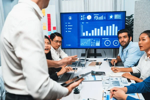 Analyst team utilizing BI Fintech to analyze financial data at table in meeting room. Businesspeople analyzing BI dashboard power for business insight and strategic marketing planning. Prudent