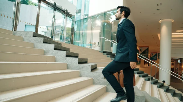 Professional business man going up the stairs. Successful man going up the stairs while explore a new thing. Represented traveling, getting a promotion, finding a new job, increasing skill. Exultant.