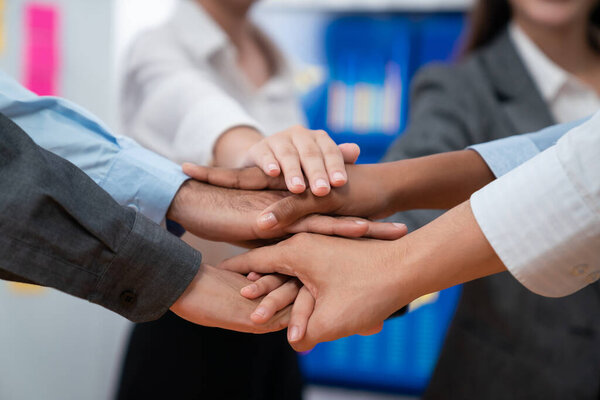 Многорасовые офисные работники ручной клади демонстрируют солидарность, командную работу и доверие к разнообразному сообществу. Бизнесмены объединяются для успеха бизнеса через синергию и сотрудничество с помощью ручного штабелирования. Конкорд