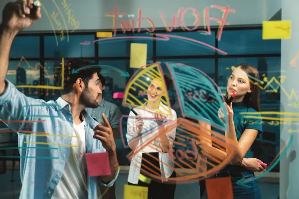 ナイトオフィスでガラスの壁に書いたプロのビジネスマンは 同僚が注意深く耳を傾けています 共に働くビジネスチームのグループ ブレインストーミング マーケティングのアイデアを共有 ビジネスプラン トレーサリー — ストック写真