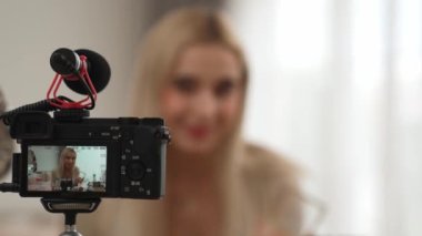 Güzellik ve kozmetik öğretim videosu içeriği yapan kamera görüntüsü kadını ya da perde arkası görüntüsü. Güzellik blogcusu izleyicilere ya da sosyal medya takipçilerine güzellik hizmetinin nasıl uygulanacağını gösteriyor. Blithe