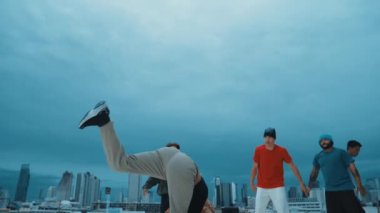 İspanyol hipster dansları şehrin mavi gökyüzü manzaralı çok kültürlü arkadaşlarıyla çevrili. Çatıda bir grup sokak dansçısı sahne alıyor. Aktif, eğlenceli, mutlu atmosfer. Açık hava sporu 2024 hiphop..