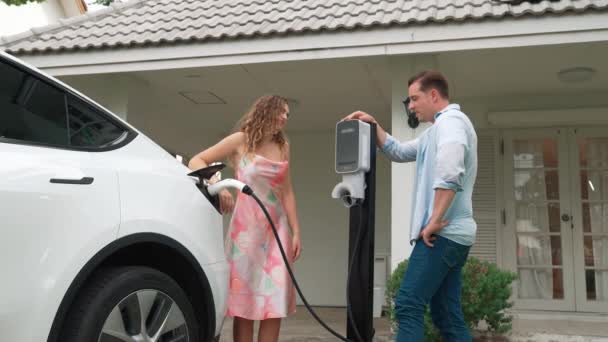 一对快乐可爱的夫妇 从电动车充电站购买了环保的 有意识的充电电动车 电动汽车技术被用作未来可持续发展的替代交通工具 太奇怪了 — 图库视频影像