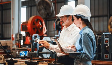Metal fabrikası mühendisi çelik endüstriyel makineleri teftiş ediyor. Bu da liderliği tesiste makine mühendisliği denetçisi olarak gösteriyor. Panorama
