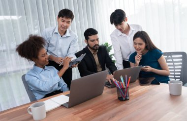 Mutlu iş adamları birlikte çalışır, şirket ofisinde tartışırlar. Profesyonel ve çeşitlilik takım çalışması iş planını bilgisayarda tartışır. Modern çok kültürlü ofis çalışanı. Uyum