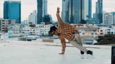 İspanyol break dansçı B-boy dansçısının ayak seslerini şehir manzaralı ya da gökdelenli çatıda pratik yapıyor. Genç modern dans grubu hip hop hareketi yapıyor. Tarz, moda, aksiyon. Açık hava sporu 2024 hiphop..