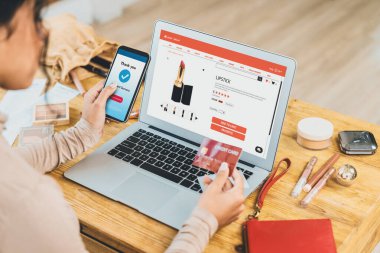 İnternet pazarından alışveriş yapan kadın modern yaşam tarzı için satış malzemeleri arıyor ve önemli siber güvenlik yazılımları tarafından korunan cüzdandan çevrimiçi ödeme için kredi kartı kullanıyor