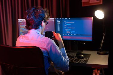 Uygulama pc ekranları ile çevrili çevrimiçi yazılım geliştirme bilgilerini yoğunlaştıran IT geliştiricisi, neon modern ofis evindeki web sitesinde yazılım için program yaratıyor. Toplayıcı.