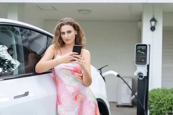 Moderni Ympäristöystävällinen Nainen Lataa Sähköauton Kotoa Latausasemalta Innovatiivinen Teknologian Käyttö — kuvapankkivalokuva