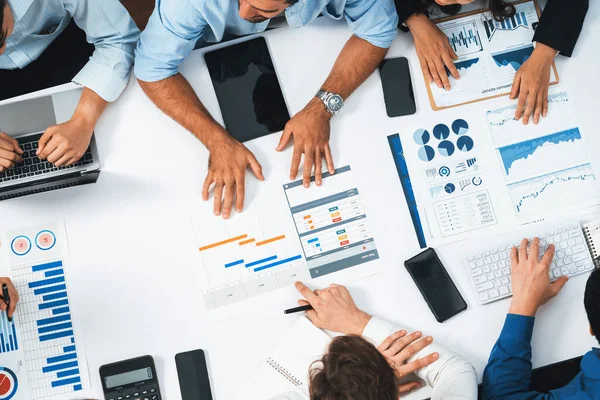 stock image Top view analyst team utilizing BI Fintech to analyze financial data at table in meeting room. Analytic BI dashboard power on paper for business insight and strategic marketing planning. Prudent