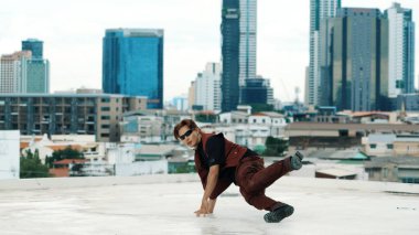 Profesyonel Asyalı break dansçı B çocuk dansı yaparken çatıda çok kültürlü arkadaşlar var. Genç modern dans grubu hip hop hareketi yapıyor. Tarz, moda, aksiyon. Açık hava sporu 2024. ÇalışmaComment.