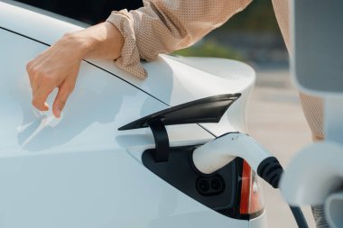 Kapalı el, şehrin park alanındaki şarj istasyonundan elektrikli araba aküsünü şarj etmek için EV şarj aleti yerleştirdi. Sürdürülebilir çevre dostu şehir yolculuğu için şarj edilebilir EV araba. Yararlı