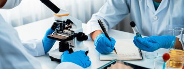 Laboratuvar araştırma ekibi, bilimsel uzmanlık ve laboratuvar ekipmanları ile sağlık hizmetlerini ilerletiyor, yeni ilaçlar araştırıyor ve laboratuvarda tedavi geliştiriyor. Panorama Katı