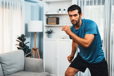 Atletik ve sporcu erkek vücut egzersizinde koşuyor. Formda fiziği ve sağlıklı spor yaşam tarzı için. Gaiety evde egzersiz eğitimi.