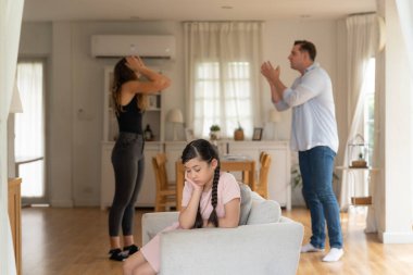 Sinirli ve mutsuz genç bir kız oturma odasında ebeveyninin tartışması yüzünden gerginliğin ortasında kanepede oturuyor. Sağlıksız ev hayatı ve travmatik çocukluk depresyona dönüşür.