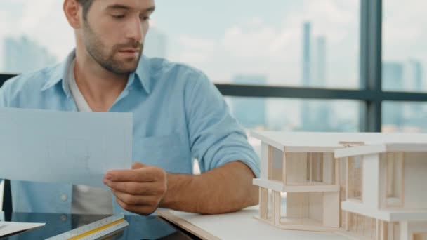 专业工程师在测量房屋模型和用摩天大楼做笔记时 要看图纸 熟练的架构师策划 用尺子设计建筑模型 小道消息 — 图库视频影像
