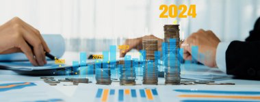 Büyüyen madeni para yığını iş yatırımını ve ekonomik büyümeyi simgeliyor. Finansal hedefe ulaşmak ve 2024 yılına maksimum kar sağlamak için finansal planlama yapan iş adamları. Kurnaz.