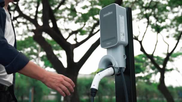 Człowiek Ładuje Akumulator Samochodu Elektrycznego Podczas Podróży Samochodem Naturalnym Lesie — Wideo stockowe