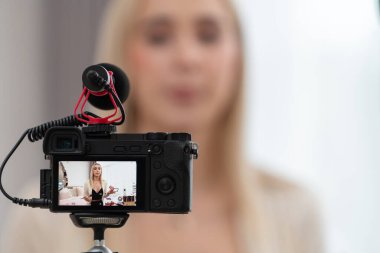 Sosyal medya için güzellik ve kozmetik video içeriği hazırlayan bulanık genç bir kadın. Güzellik etkileyicisiyle odaklanmış kamera ekranı izleyicilere ve takipçilere güzellik hizmetinin nasıl uygulanacağını gösteriyor. Blithe