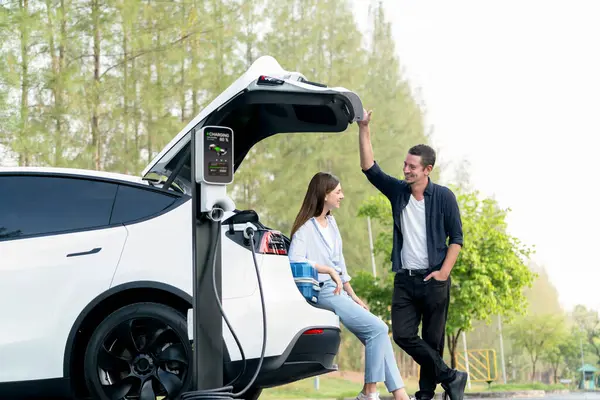 Schönes Junges Paar Lädt Die Batterie Für Das Elektroauto Auf — Stockfoto