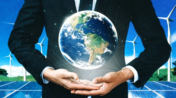 Alternatif enerji ile sürdürülebilirlik gelişimi kavramı. Çevre dostu rüzgar türbini çiftliği ve arka planda yeşil yenilenebilir enerji olan gezegenle insan eli ilgilenir. uds