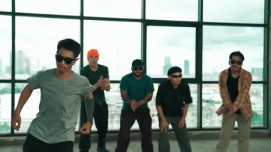 Profesyonel hipster, çeşitli çok kültürlü arkadaşlarıyla birlikte adım atıp dans ediyor. Gökyüzü dövüşçüsü ve şehir manzaralı pencerenin yanında duruyor. Break dans. Açık hava sporları konsepti 2024 hiphop..