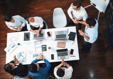 Üst düzey ofis çalışanları stratejik iş pazarlama toplantısı üzerine anlaşma yaptıktan sonra el sıkışıyor. Takım çalışması ve olumlu tutum verimli ve destekleyici bir iş yeri yaratır. Tedbirli