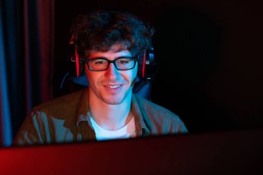 Genç oyun flaması takımı, Esport ile birlikte neon ışıklı odada kulaklık takarak online dövüş kazanan oyuncuları topluyor. Bir sonraki seviyeye rakip kazanmak için strateji planı uyguluyorum. Toplayıcı.