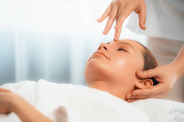 Kafkasyalı kadın stres önleyici kafa masajından ve lüks tatil beldesi ya da otel spa salonundaki modern ışık ortamında yüz güzelliği eğlencelerini şımartmaktan hoşlanıyor. Sessiz.