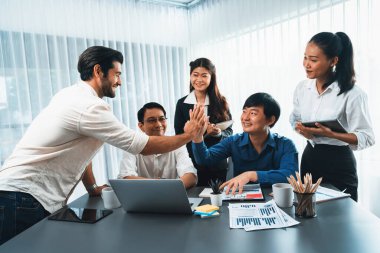 Çeşitli ofis çalışanlarından oluşan bir grup, stratejik iş pazarlama planlaması konusunda anlaşma yaptıktan sonra beşlik çaktı. Takım çalışması ve olumlu tutum verimli ve destekleyici bir iş yeri yaratır. Tedbirli