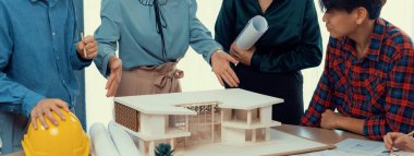 Mimari takım analizi ve ev modeli, plan ve mimari ekipmanlarla toplantı masasında ev inşaatı hakkında beyin fırtınası. Yaratıcı tasarım ve takım çalışması. Filizlenen.