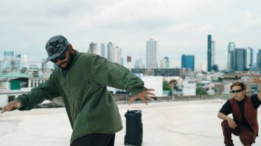 Profesyonel break dans takımı çatıda çok kültürlü arkadaşlar varken break dans alıştırması yapıyor. Genç modern dans grubu hip hop hareketi yapıyor. Tarz, moda, aksiyon. Açık hava sporu 2024. ÇalışmaComment.