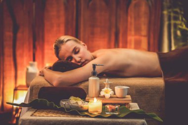 Aromaterapi masajı ambiyansı ya da spa salonu kompozisyon düzeneği bulanık kadınlara odaklı dekor mumları ve spa aksesuarları ile tatil köyü veya otel arka planında keyifli aroma spa masajı yapan. Sessiz.