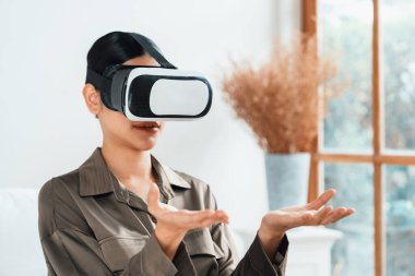 Sanal gerçeklik gözlüğü kullanan genç bir kadın online alışveriş deneyimi için evde. Sanal gerçeklik VR yeniliği dijital eğlence yaşam tarzı için optimize edildi.