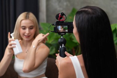 Yeşil bitki üzerine doğal güzellik ve kozmetik dersi yapan iki güzel içerik yaratıcısı bahçe videosunu terk ediyor. Güzellik blogcusu selfie çubuğuyla sosyal medyal izleyiciye güzellik hizmetini gösteriyor. Blithe