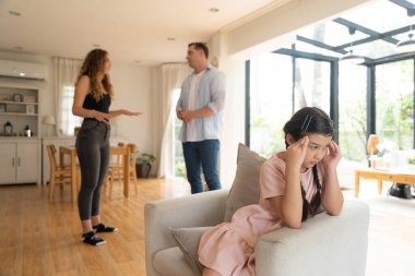 Sinirli ve mutsuz genç bir kız oturma odasında ebeveyninin tartışması yüzünden gerginliğin ortasında kanepede oturuyor. Sağlıksız ev hayatı ve travmatik çocukluk depresyona dönüşür.