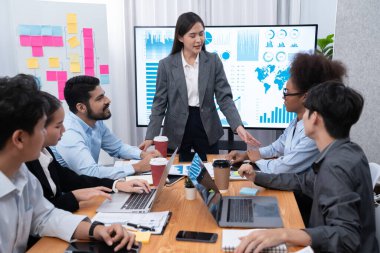 Genç Asyalı iş kadını modern toplantıda TV ekranında veri analizi paneli sunuyor. Bir grup iş adamıyla konferans odasında iş sunumu. Uyum