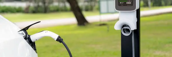 从室外绿城公园的电动车充电站充电的电动车蓄电池 自然保护与生态友好型电动车旅行 全景旗帜升华 — 图库照片