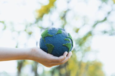 Dünya gezegenini ESG ilkesi ve çevre dostu enerjisiyle daha parlak bir gelecek için Dünya günü olarak el ele tutuşan genç çocuklar. Döngü