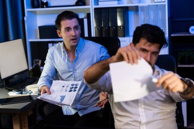 Son teslim tarihi için yüzü korkuyla oturan meslektaşlar gece vakti kağıt yırtıyorlar. Beklenmedik kazanç elde etmenin bedeli. Sakin duygularla destekleyen bir adam. Satılabilir.