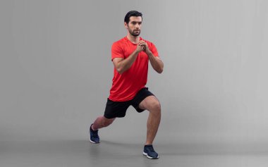 Vücut uzunluğunun tamamı atletik ve sportif genç bir adam tarafından izole edilmiş arka planda egzersiz pozisyonunda çekilmiştir. Sağlıklı aktif ve vücut bakımı yaşam tarzı.