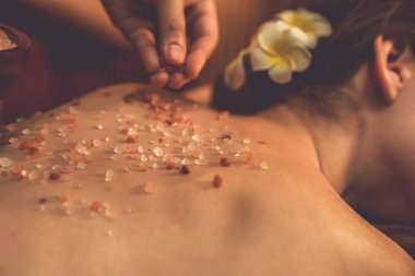 Lüks spa salonunda sıcak mum ışığı atmosferi olan kaplıca tedavisi gören kadın müşteri. Sağlık kaplıcasında güzellik tedavisiyle tuz temizliği. Sessiz.