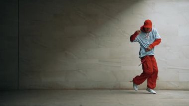 Profesyonel Asyalı hipster gri arka planlı break dansçı performansı sergiledi. Çekici bir sokak dansçısı şık kıyafetler giyerken hareketli hareketler yapar. Açık hava sporu 2024. Uzayı kopyala Yumuşak bir şekilde..