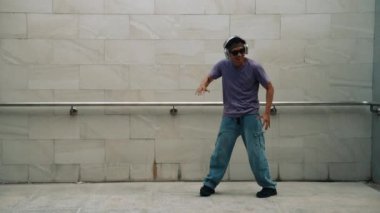 Yakışıklı hippi dans ederken müzik dinler ya da dans ederken dans eder. Çekici bir sokak dansçısı B-boy ayak sesleri çıkarıyor. Serbest dans konsepti. Yaşam tarzı. Açık hava sporu 2024. Yumuşak bir şekilde..