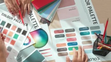 Grafik tasarımı için renk seçen iki tasarımcının çalışma masasının üst görüntüsü veya tasarımcıdan yaratıcı kromatik konsültasyon için renk uygulaması arayan istemci. Değiştirilmiş