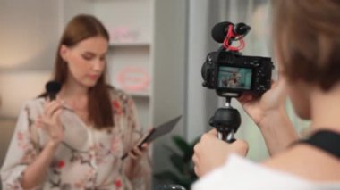 Etkilenen iki ortak canlı yayında video görüntülerini çekiyor makyaj malzemesi prim sosyal medya veya blog. Kozmetik stüdyosu ışıklandırmalı mutlu genç kız çevrimiçi pazarlama oturumu yayını için..