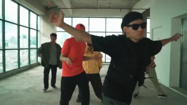 Çok kültürlü dansçılar sokak dansı yapıyor ve hip-hop müziğine geçiyorlar. Profesyonel hipster grubu gökyüzü kavgacı görünümlü bir binada serbest stil müzik eşliğinde dans ediyor. Açık hava sporu 2024 hiphop..